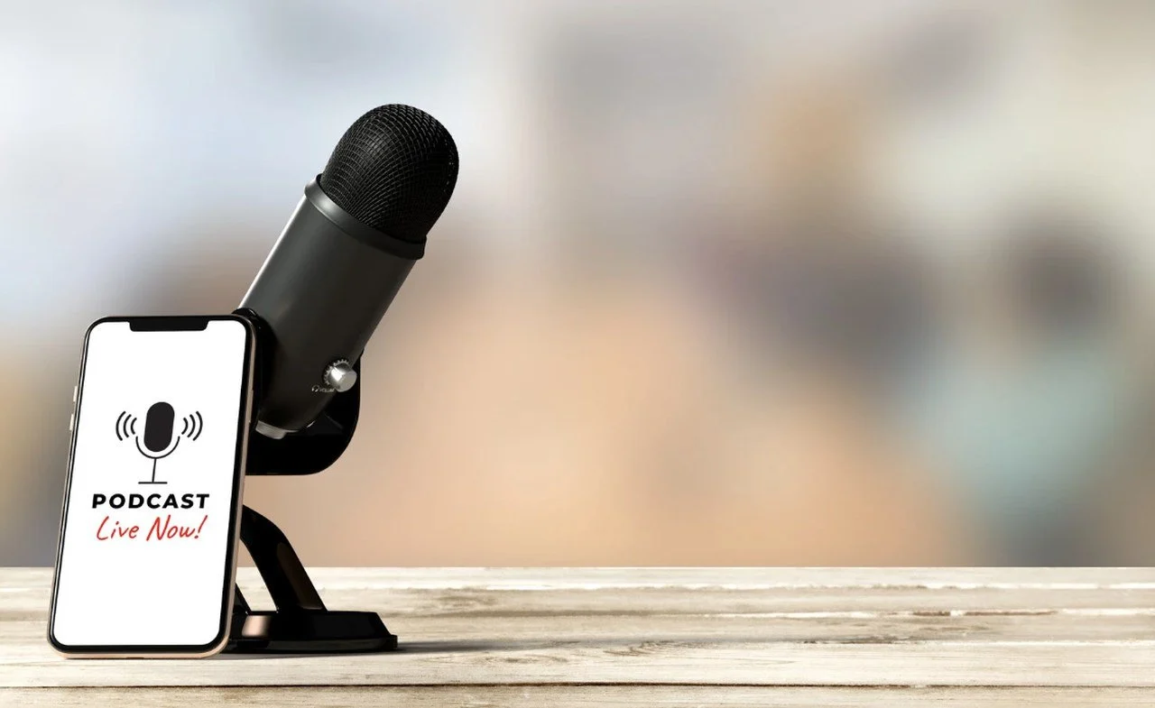 a picture of an smartphone playing ecommerce podcast with a black microphone next to it