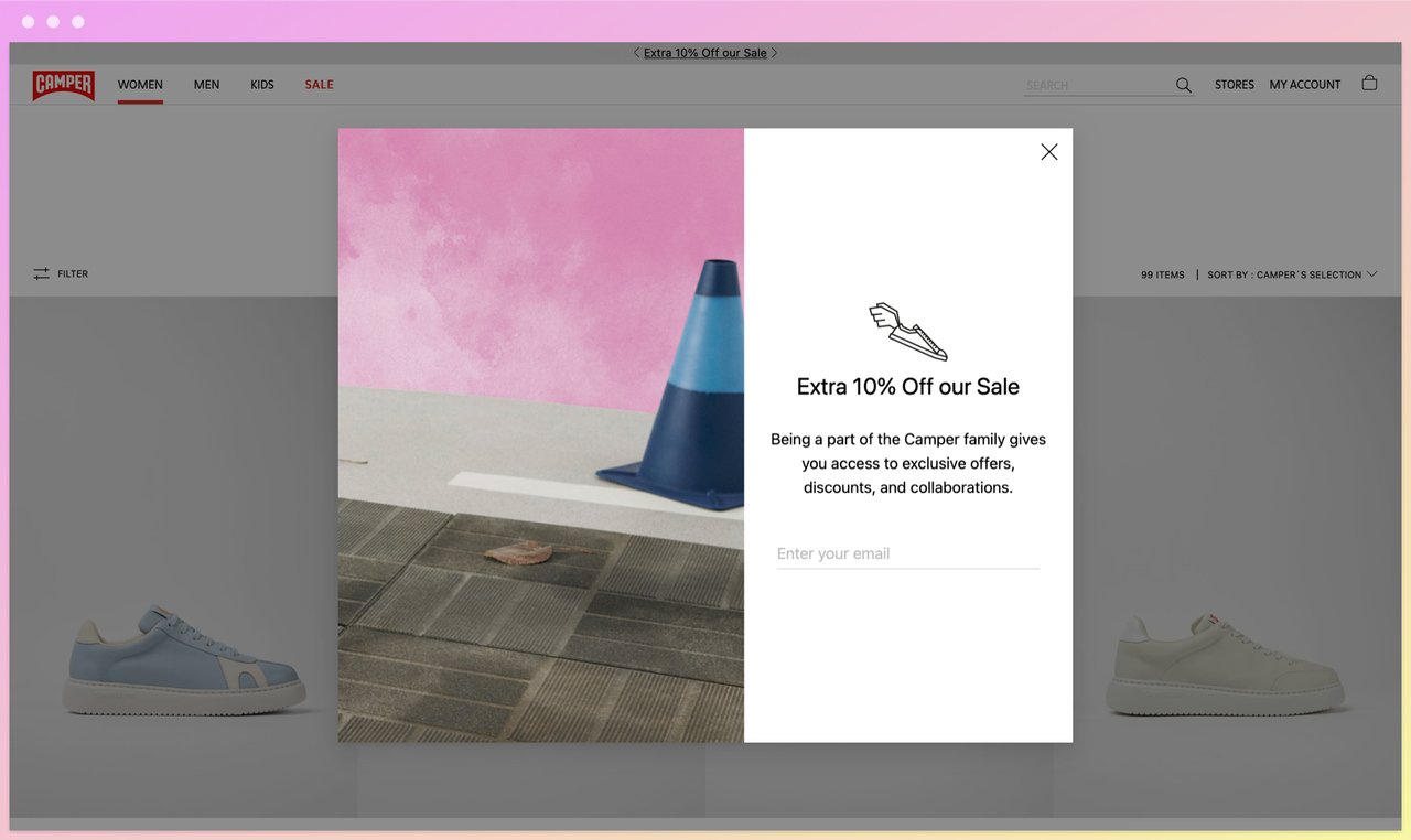 camper homepage showing a popup offering discount with an email address field and a photo of a traffic cone on a pink background