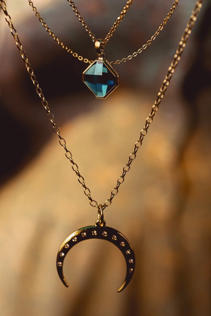 a necklacce with two symbols moon and shining diamond