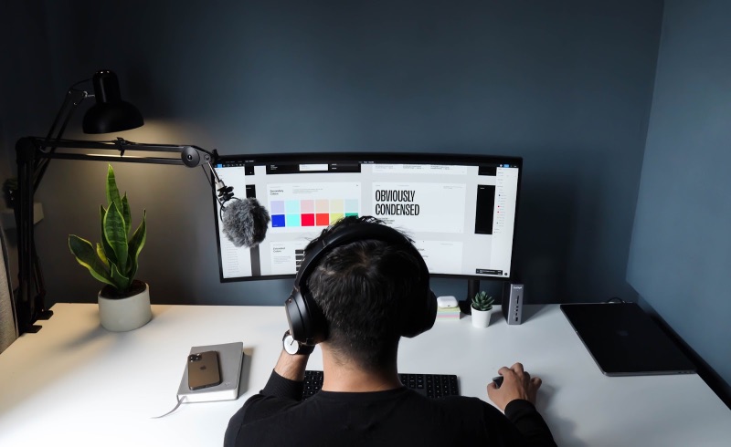 Personne avec un casque faisant de la conception graphique sur son bureau