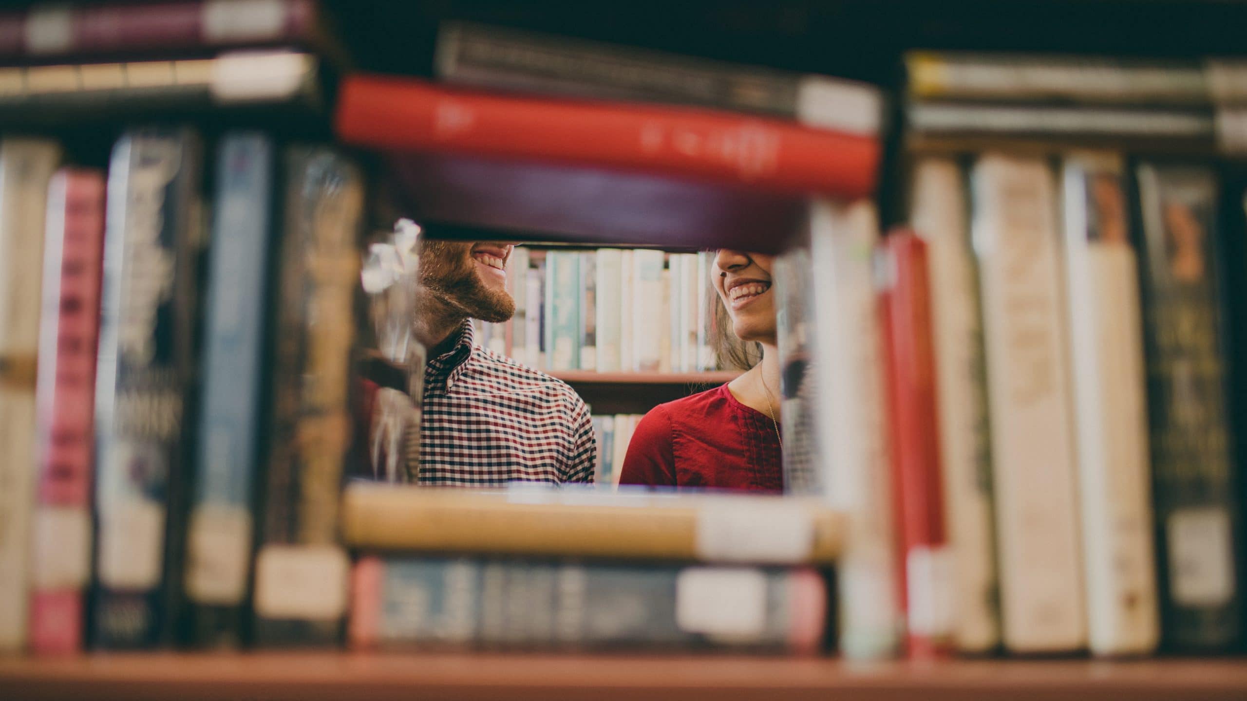 teman tersenyum di belakang perpustakaan