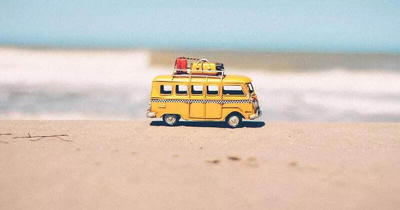 Miniaturbus sitzt an einem sonnigen Strand.