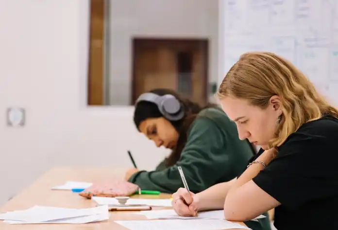 girl in black t-shirt writing on white paper