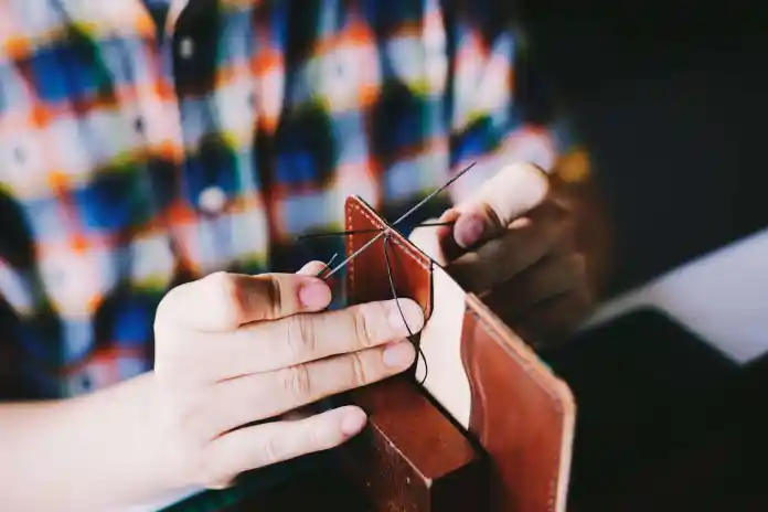 person knitting brown leather textile