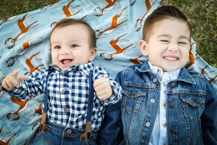 two boys laying on blue textile