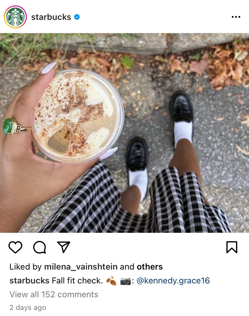 Una vista de pájaro de una mujer que sostiene una taza de Starbucks en una caminata de otoño.