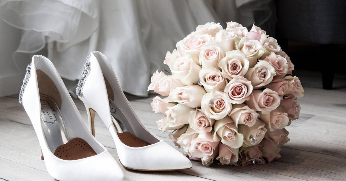 Weiße Brautschuhe und Blumenstrauß für die Hochzeit