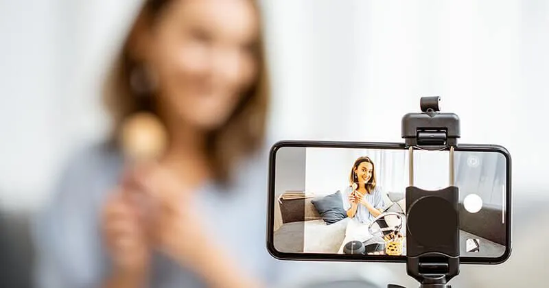 Mujer grabando un video de ella misma promocionando un producto.