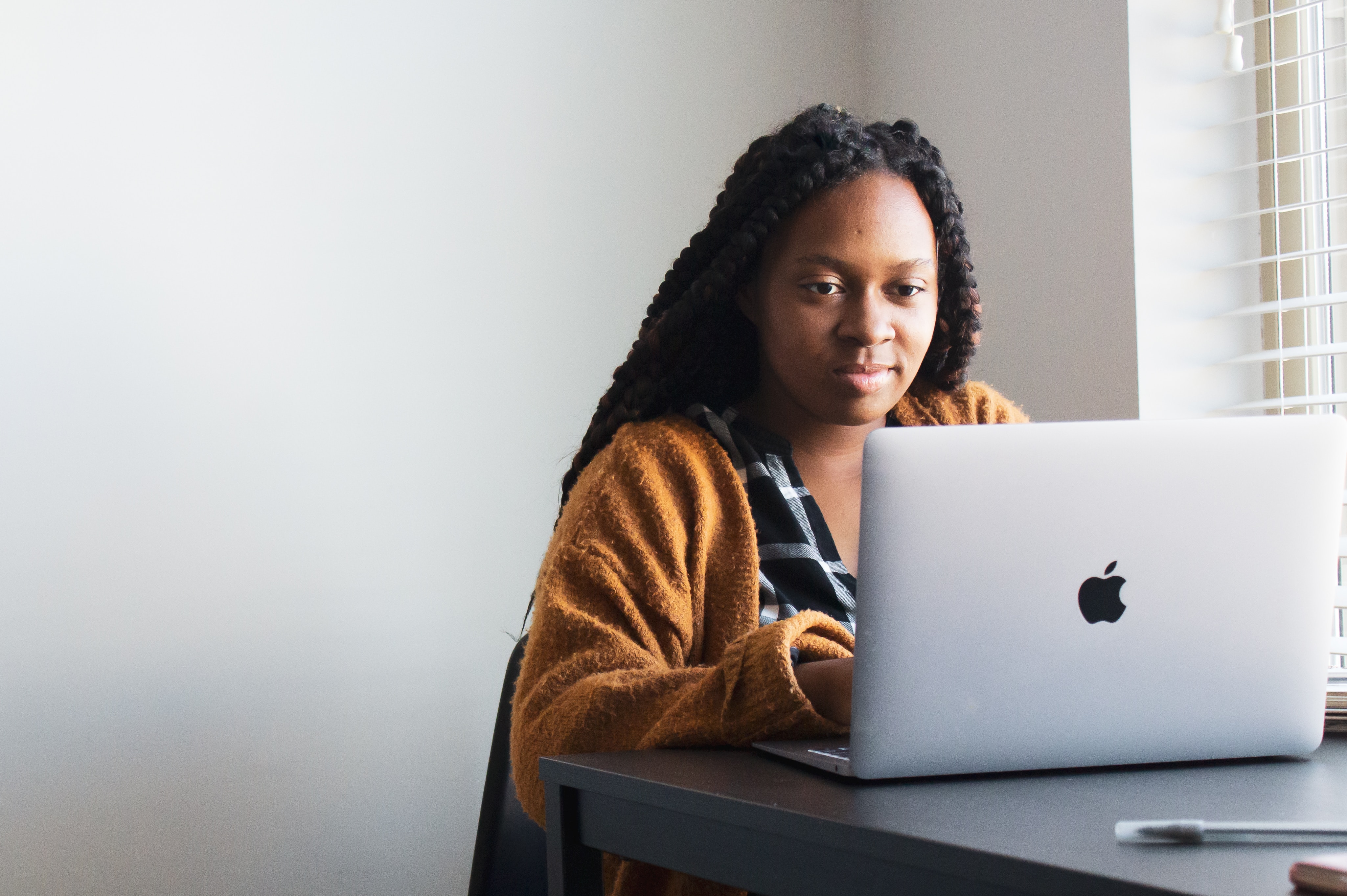 [Une femme dans une salle blanche face à la caméra tapant du contenu sur un ordinateur portable qui ne nécessitera pas la technologie IA zéro GPT]