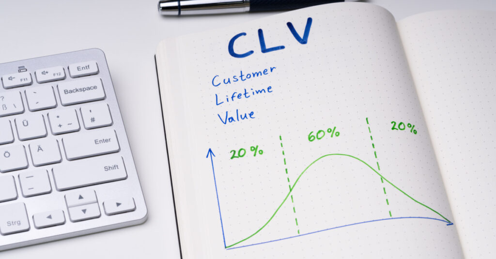 Nahaufnahme eines Notebooks neben einer Tastatur mit den Worten „Customer Lifetime Value“ und einem skizzierten Diagramm