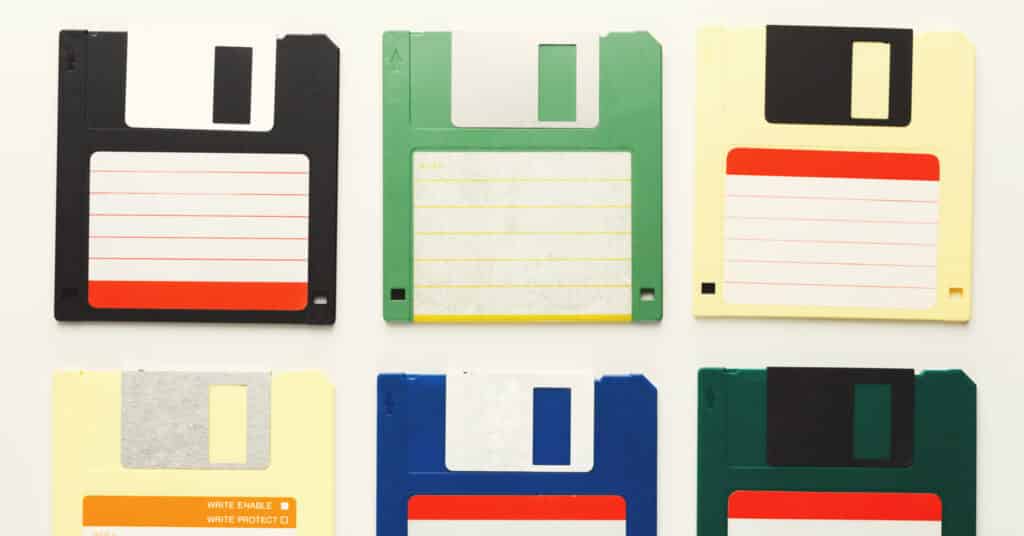 Floppy disk lama diisolasi pada latar belakang putih. Tampilan atas perangkat penyimpanan retro magnetik, disket berwarna-warni.