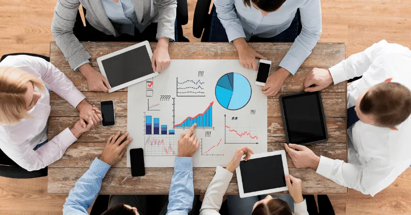 Des professionnels examinent les données et les analyses autour d'une table.