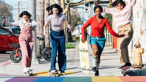 meninas atravessando a rua com patins com estilos coloridos