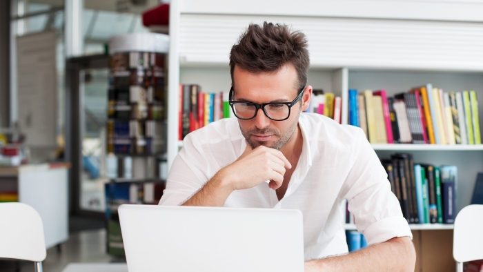 uomo che legge su un laptop