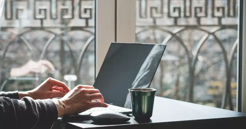 Manos esperando por encima del teclado del portátil.