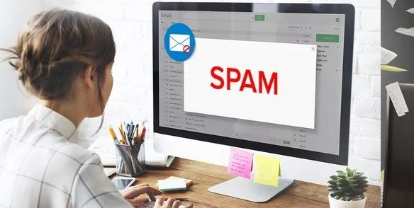 una ragazza che lavora al suo computer e la sua e-mail finisce nello spam