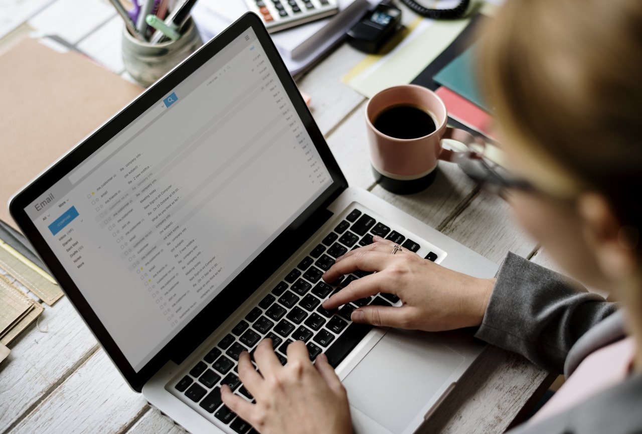 mujer de negocios revisando correos electrónicos en la computadora portátil