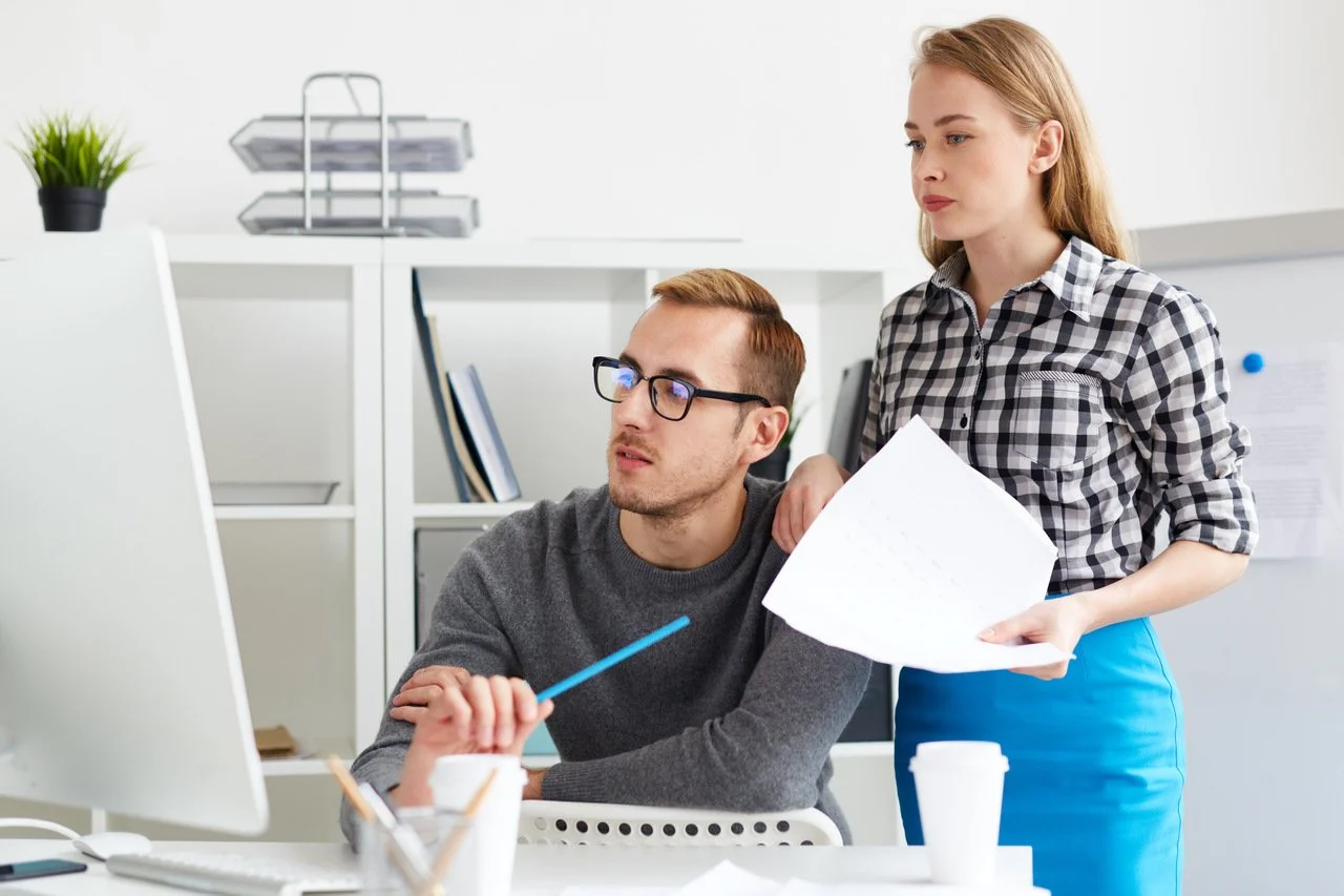 junge kollegen, die auf den computerbildschirm schauen