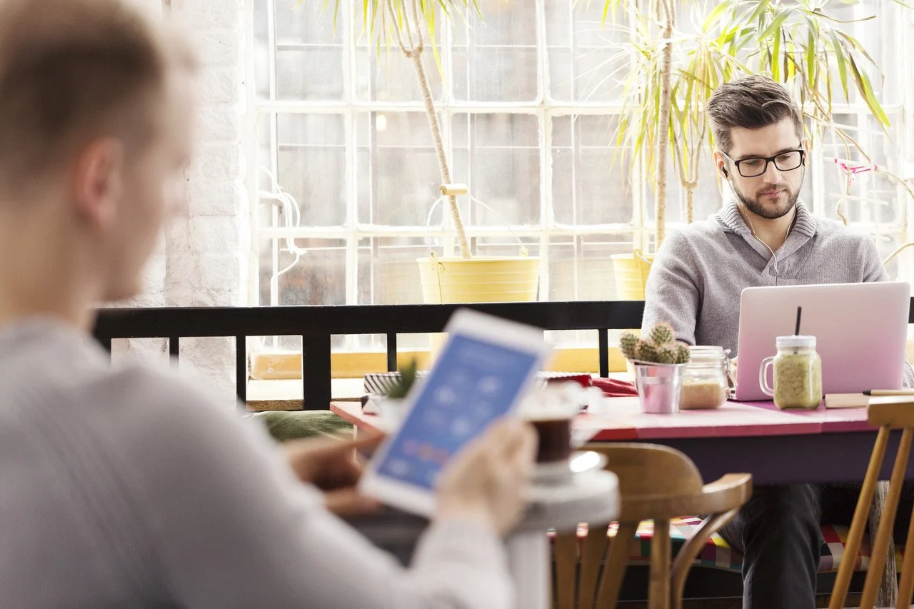 deux hommes brosing sur ordinateur portable et mobile