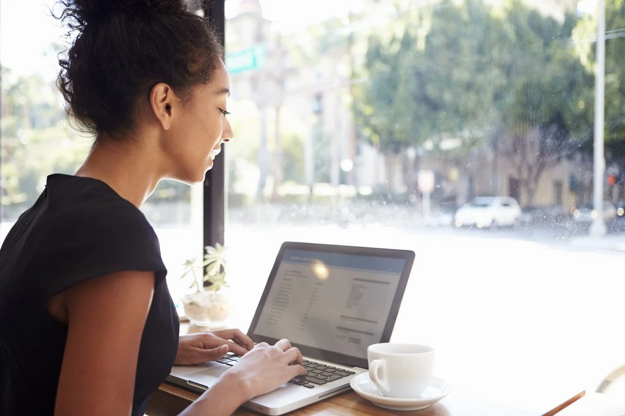 Geschäftsfrau, die in einem Café am Laptop arbeitet