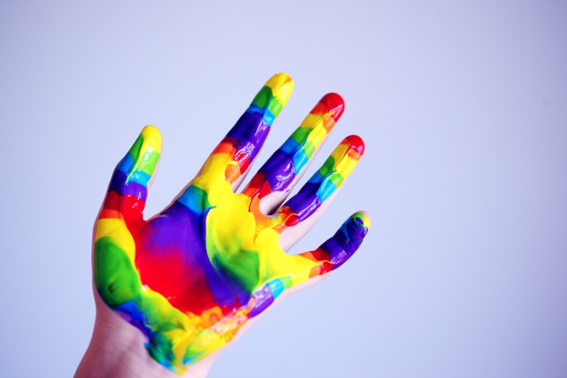 Hand mit Regenbogenfarbe bedeckt