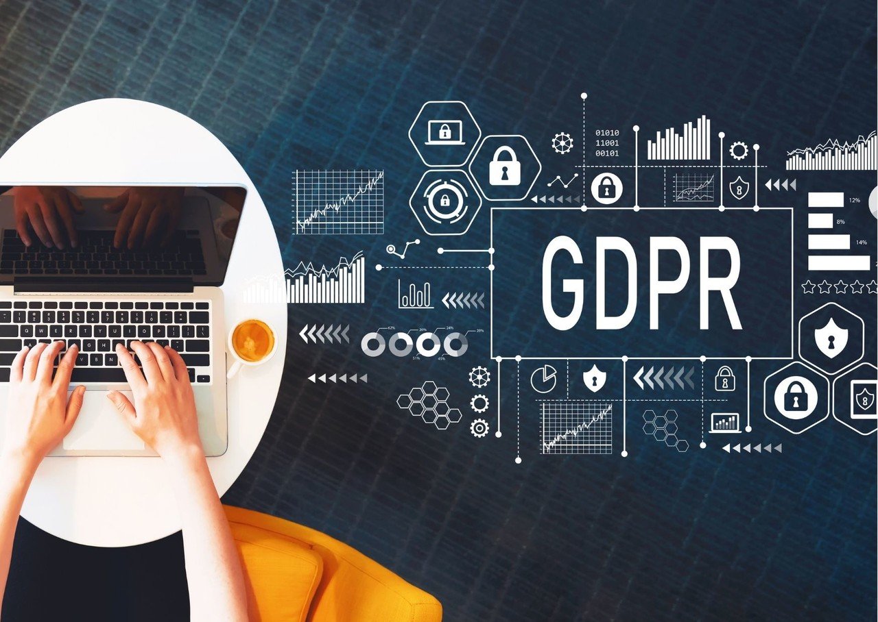 ordinateur portable et mains tapant sur l'ordinateur portable avec un script gdpr et des fonctions montrant l'importance du gdpr