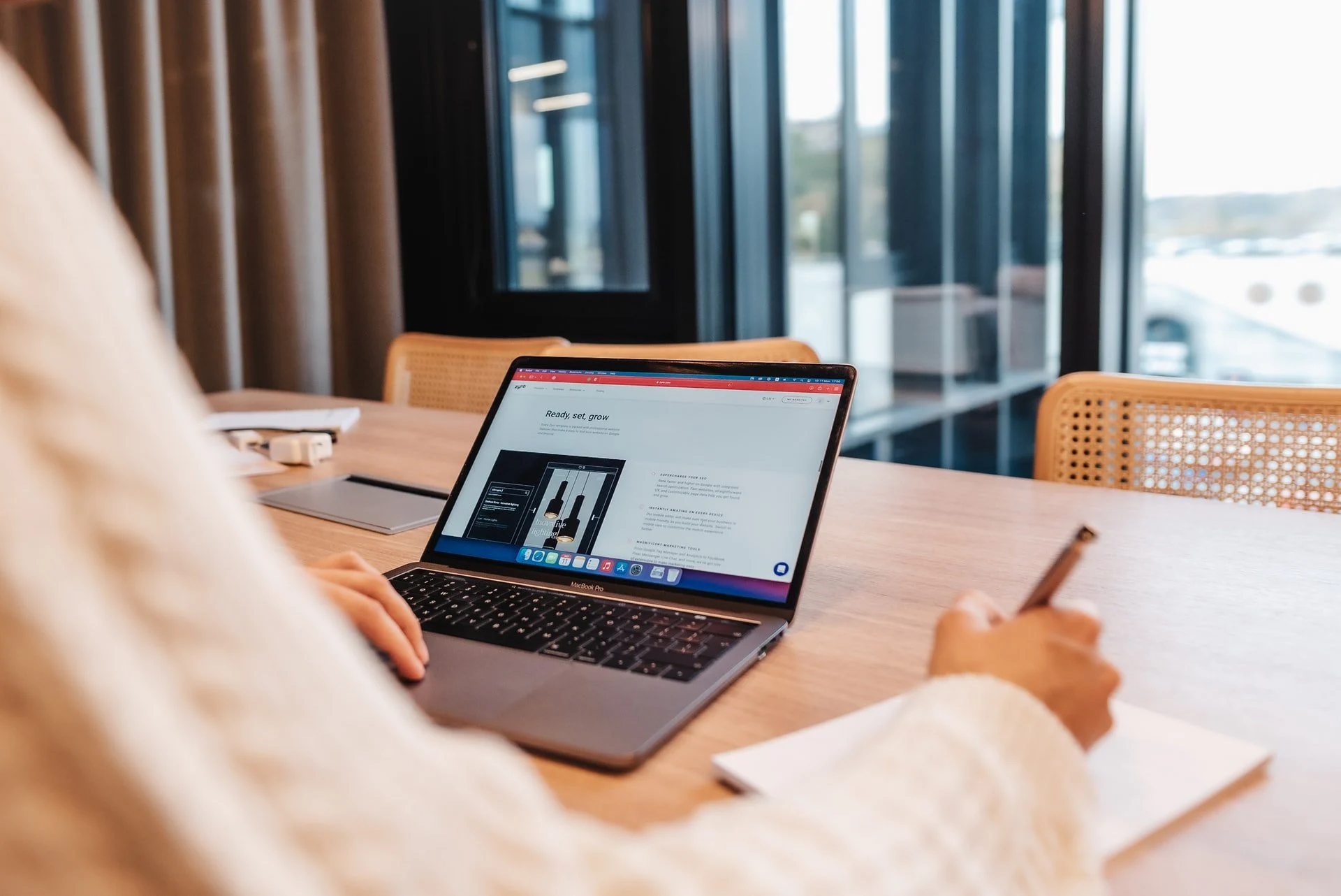 um homem trabalhando com um laptop e visualizando um site zyro